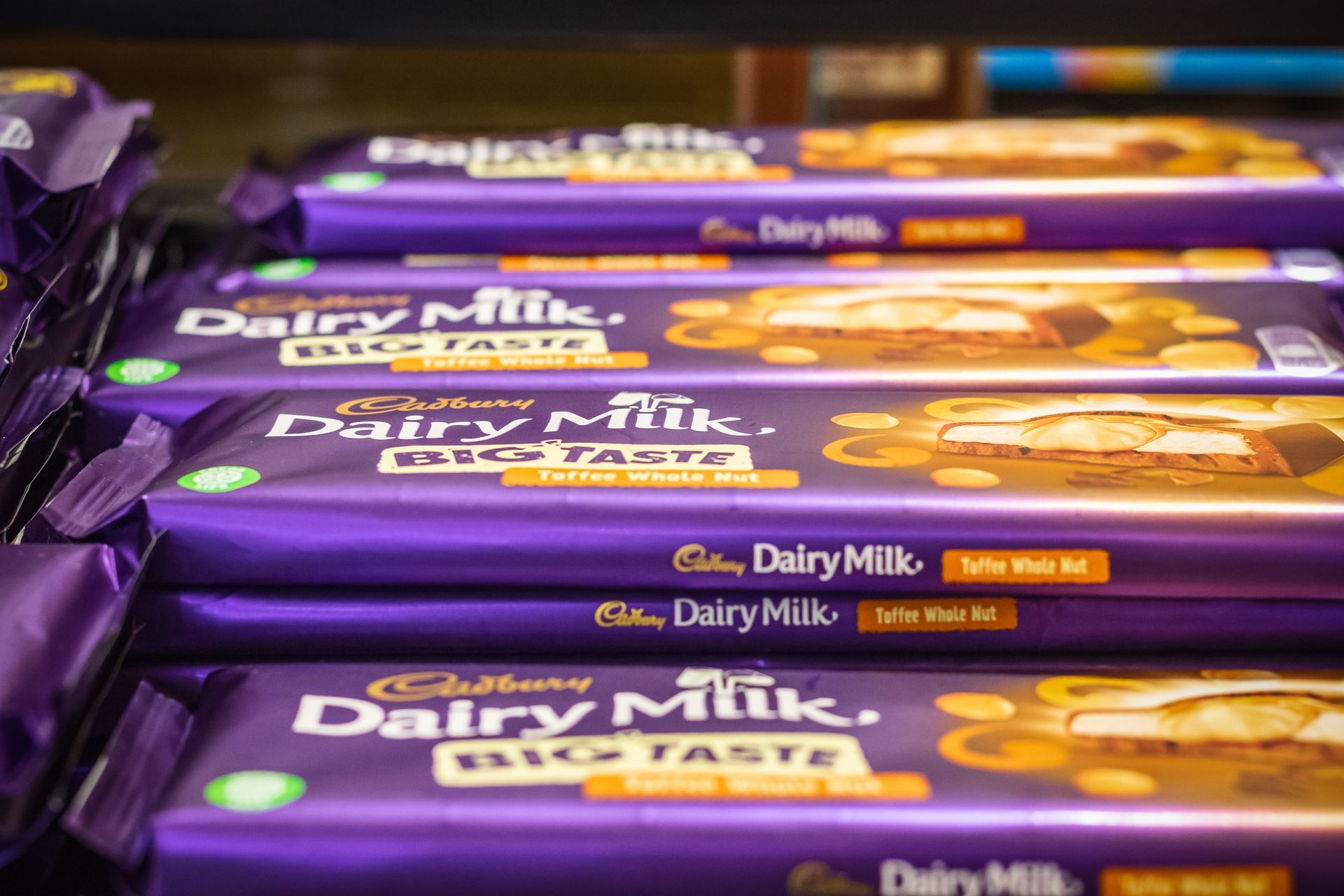 Close-up of stacked Cadbury Dairy Milk Big Taste chocolate bars in purple packaging.