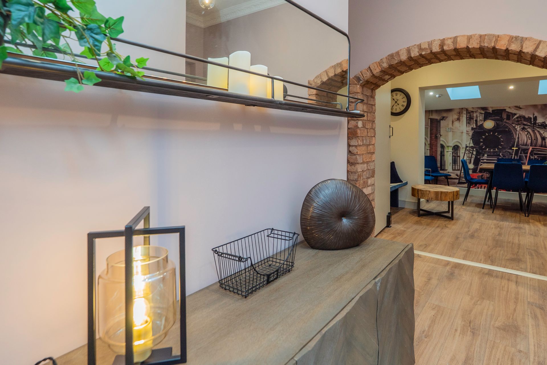 A bedroom with a large bed, gold accents, side tables with lamps, a chair, and a window.