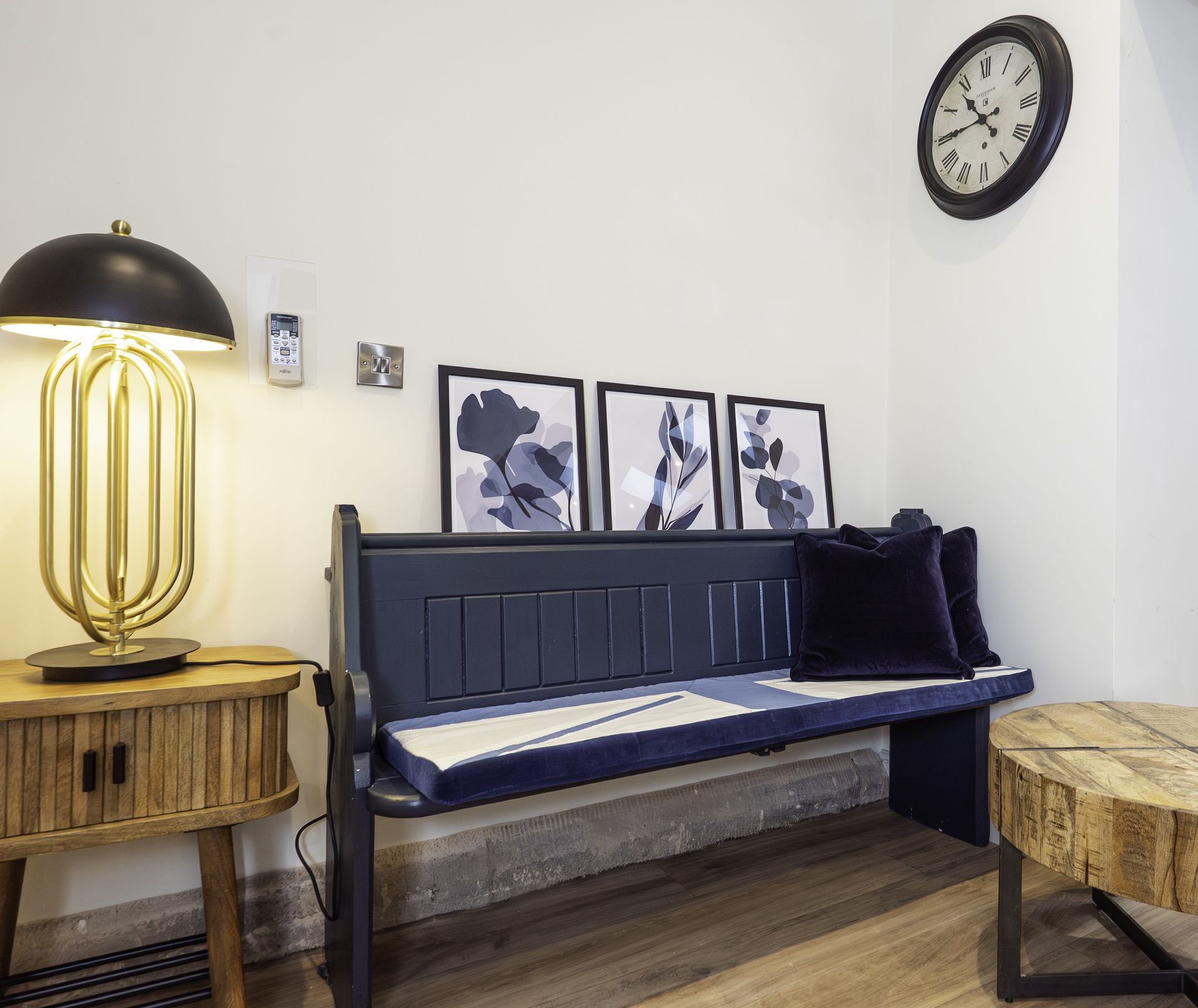 A bedroom with a large bed, gold accents, side tables with lamps, a chair, and a window.
