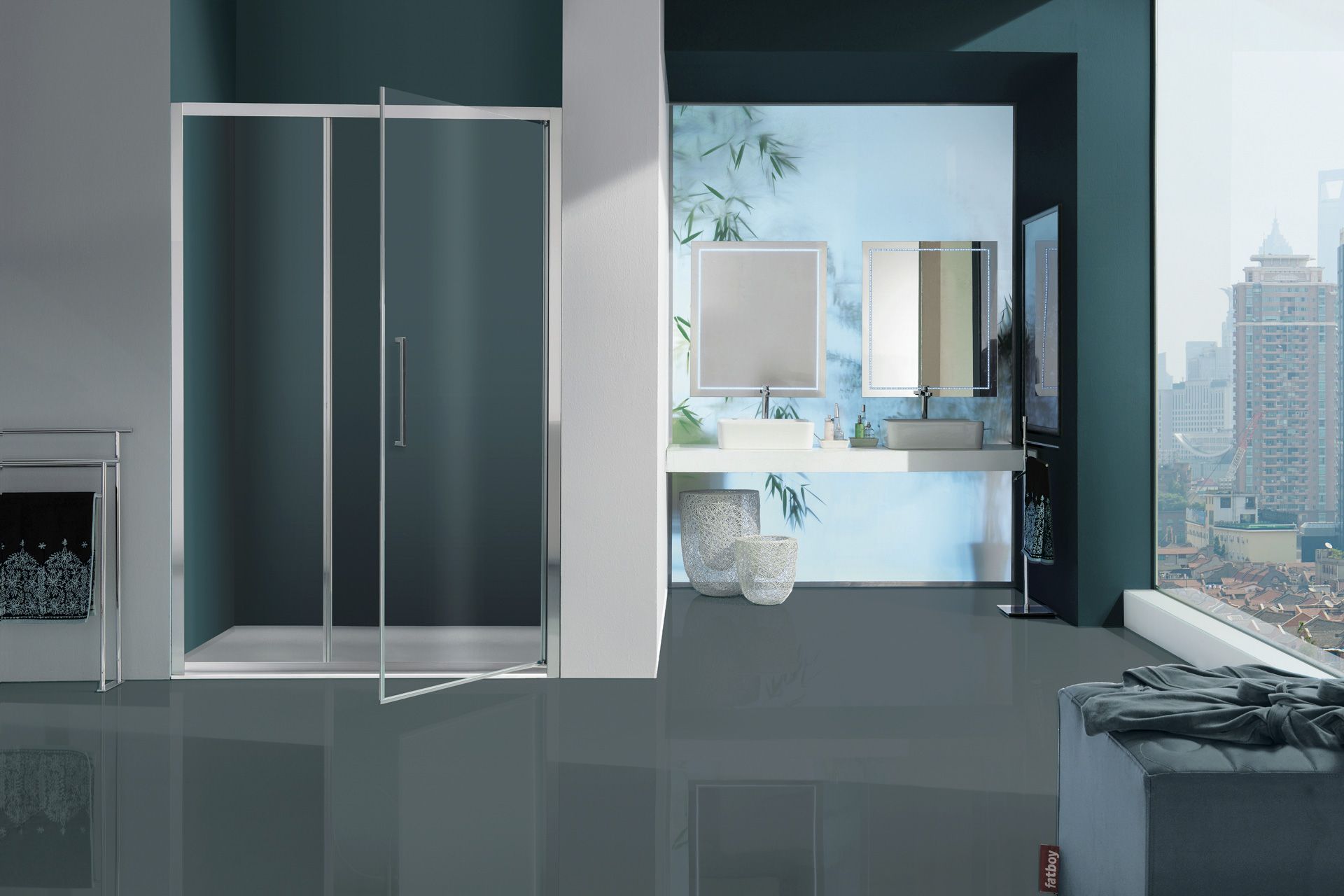 Un bagno moderno dotato di doccia con box in vetro, mobile lavabo bianco con due specchi e vista panoramica sulla città attraverso le finestre.