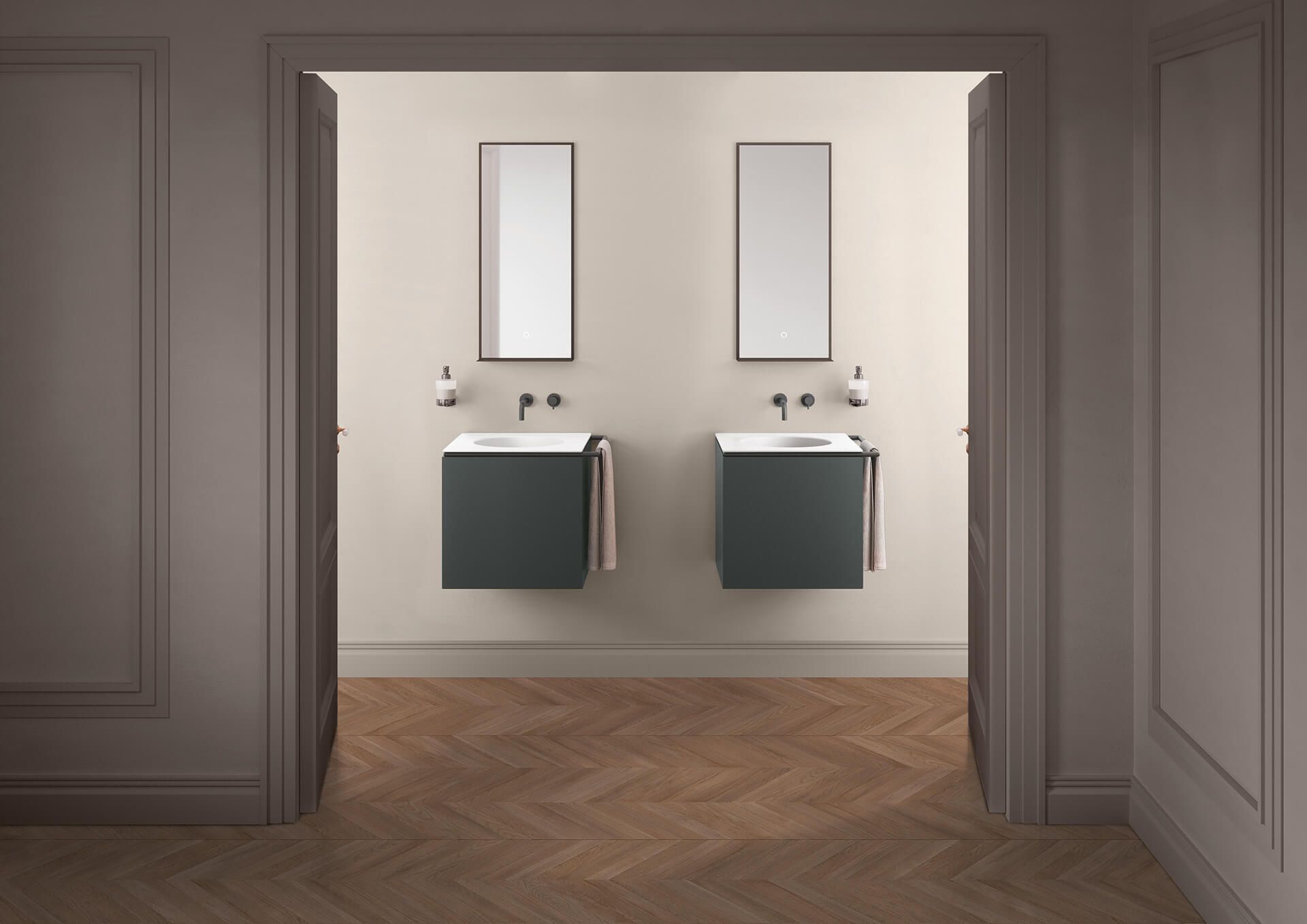 Due mobili da bagno sospesi di colore grigio scuro con lavabi bianchi e specchi alti, posizionati al centro di una parete chiara sopra un pavimento in legno.