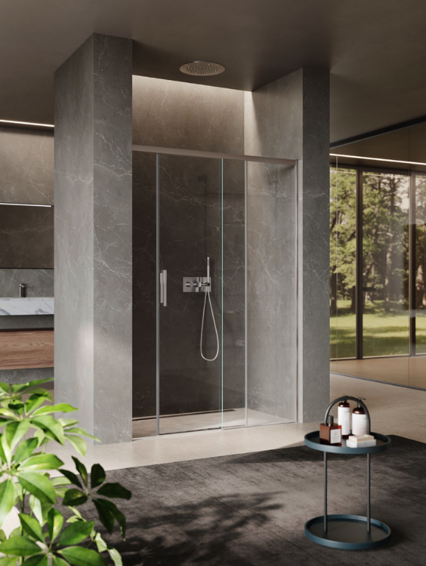 Una moderna cabina doccia in vetro con maniglia cromata, incorniciata da pareti in pietra grigia, con un piccolo tavolino in primo piano.