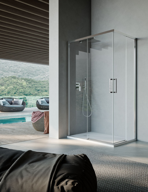 Box doccia angolare in vetro con struttura e maniglia cromate, installato in un bagno moderno con vista su una piscina esterna.