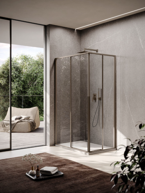 Un bagno moderno con cabina doccia a filo pavimento con profili in bronzo scuro, piastrelle in pietra grigia e un'estetica minimalista.