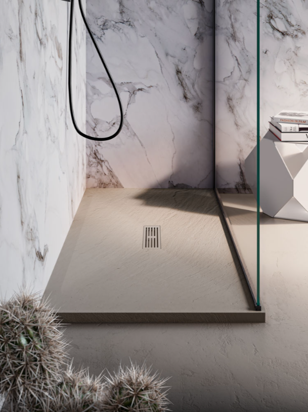 Una moderna cabina doccia con piatto doccia beige testurizzato, pareti con motivo effetto marmo, box doccia in vetro e scarico lineare.