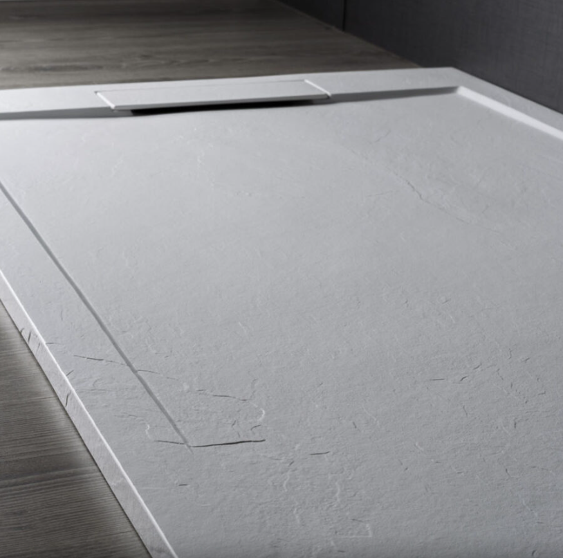 Piatto doccia rettangolare di colore grigio chiaro con effetto pietra, dotato di copertura di drenaggio integrata al centro di un lato.