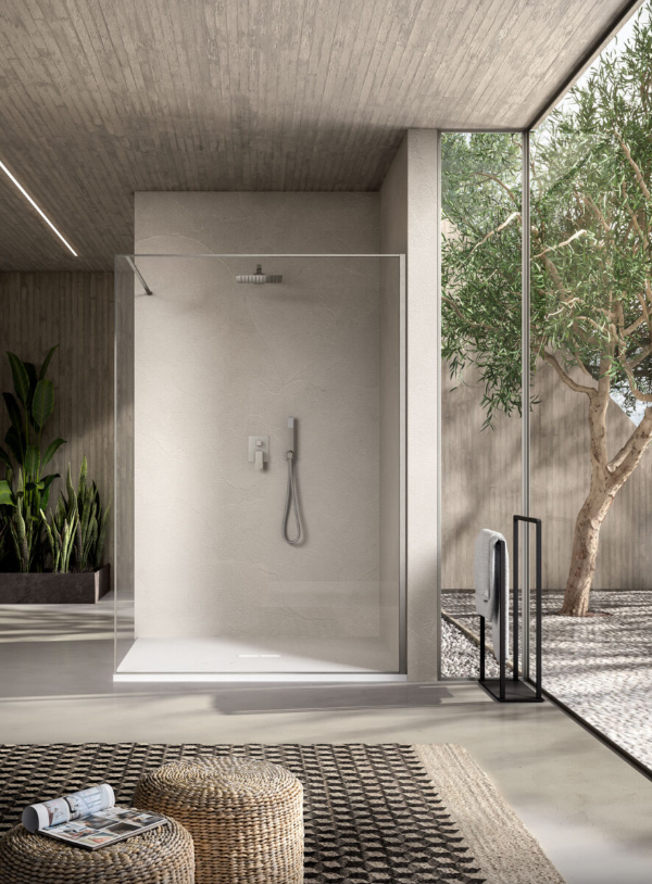Un bagno moderno e minimalista con cabina doccia in vetro, pavimento in pietra e un'ampia finestra con vista su un albero.
