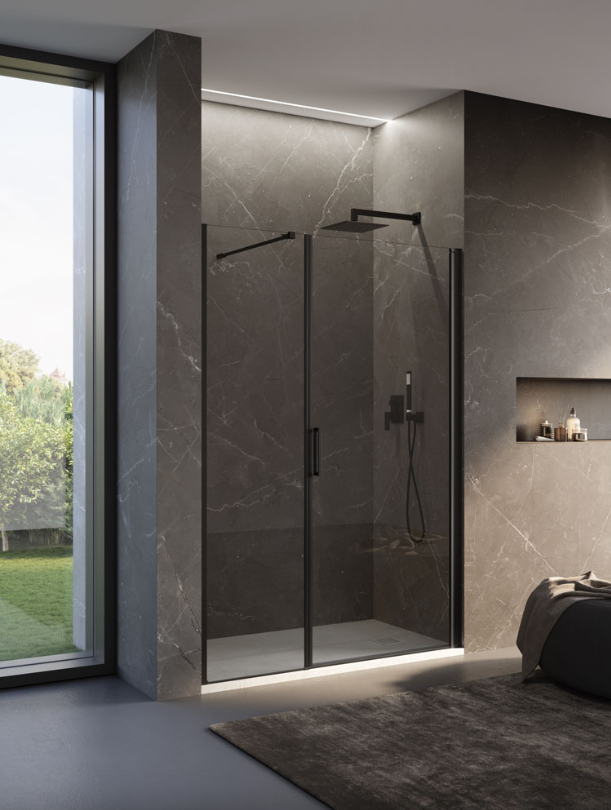 Un box doccia in vetro con struttura nera, soffione a pioggia e doccetta a mano, il tutto in un bagno rivestito in pietra scura.