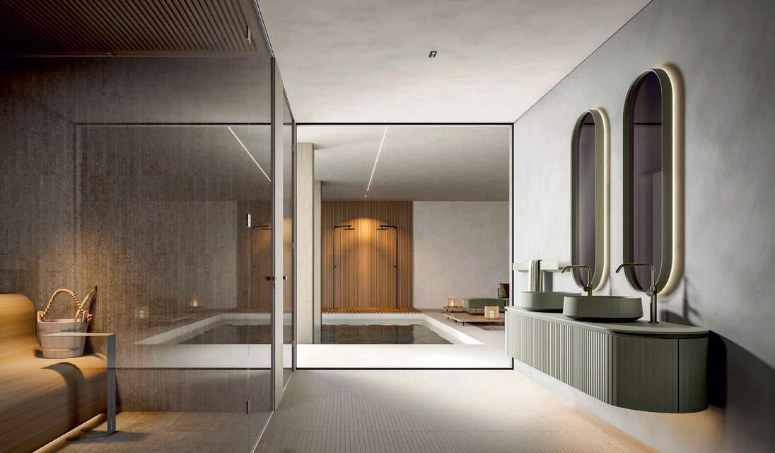Un bagno moderno con doppio lavabo, specchi verticali e una zona salotto con pareti in vetro che si affaccia su una parete in legno.