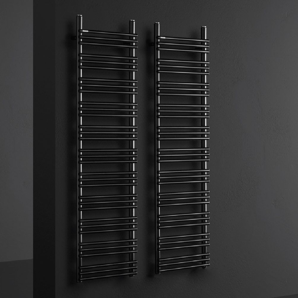 Due sottili termoarredo a scala di colore nero opaco, montati uno accanto all'altro su una parete scura e minimalista.