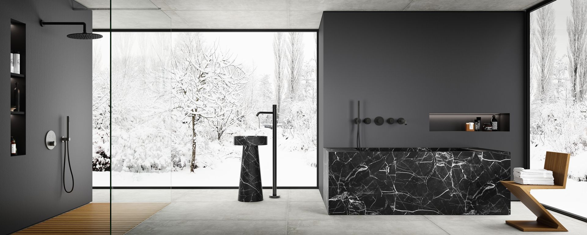 Un bagno moderno e minimalista con vasca e lavabo freestanding in marmo nero, sullo sfondo di una vetrata a tutta altezza che offre una vista mozzafiato sulla foresta innevata.
