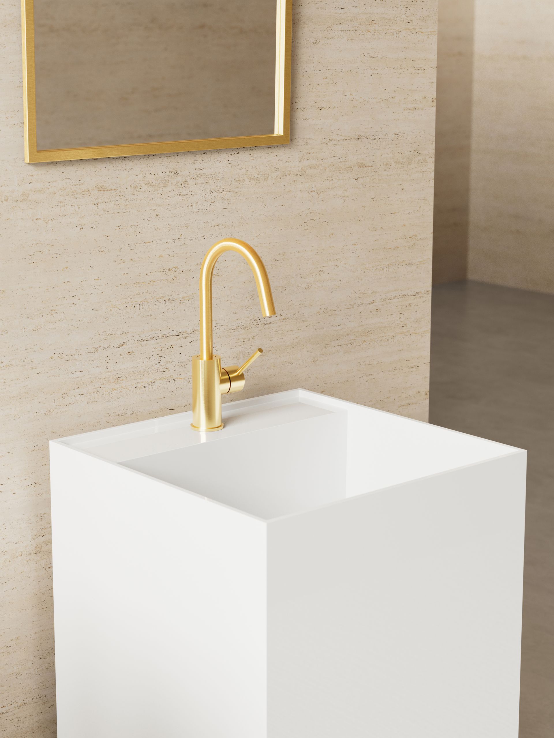 Un rubinetto color oro montato su un moderno lavabo a colonna quadrato bianco, addossato a una parete in pietra chiara e texturizzata.