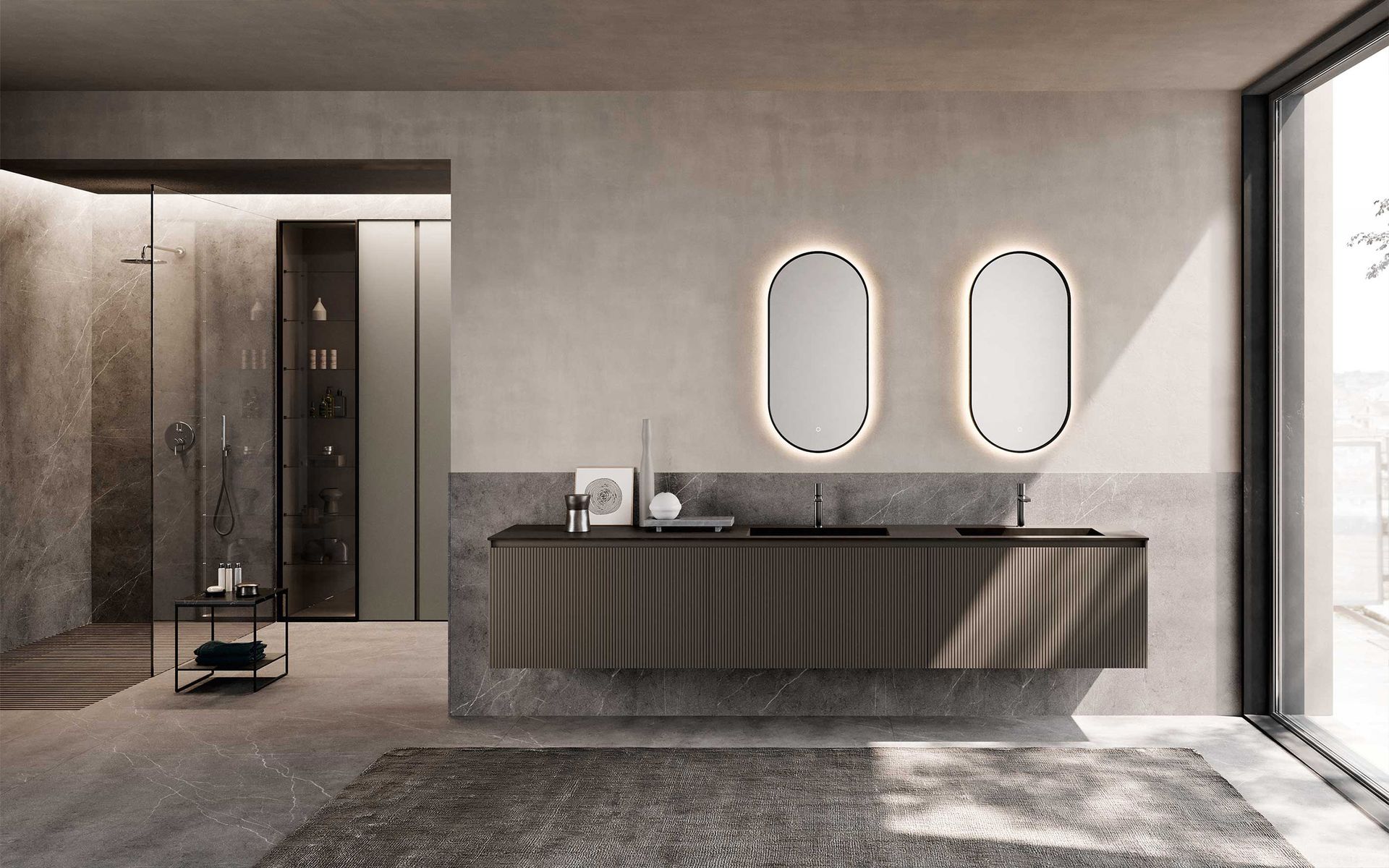 Un bagno moderno caratterizzato da un mobile lavabo sospeso di colore scuro, due specchi ovali retroilluminati e una cabina doccia in vetro sulla sinistra.