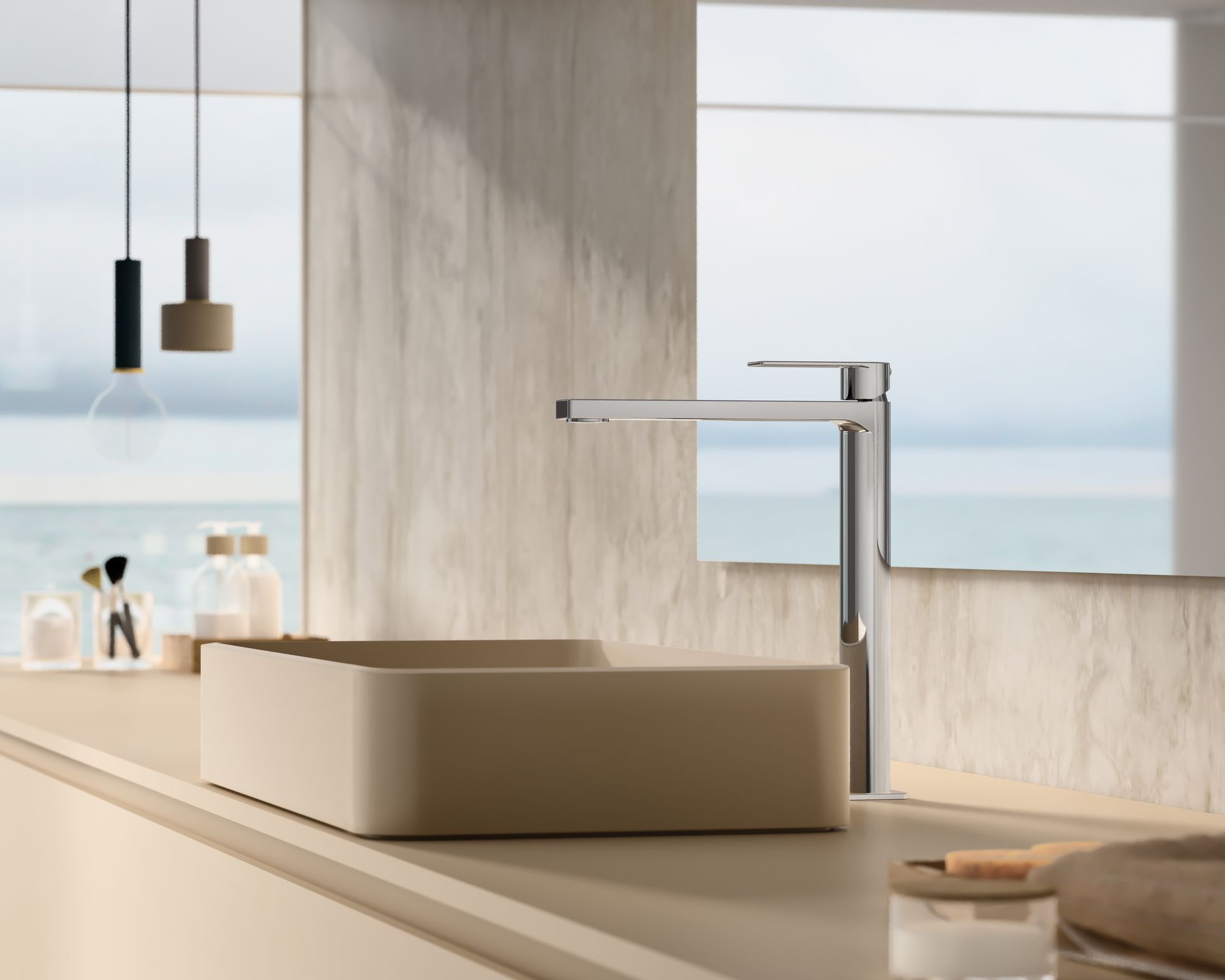 Un moderno lavabo da bagno con un alto rubinetto cromato, incastonato su un piano d'appoggio dai toni chiari e con uno sfondo marino sfocato.