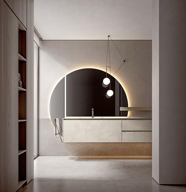 Un bagno moderno con mobile lavabo sospeso, grande specchio semicircolare retroilluminato e lampade a sospensione minimaliste.