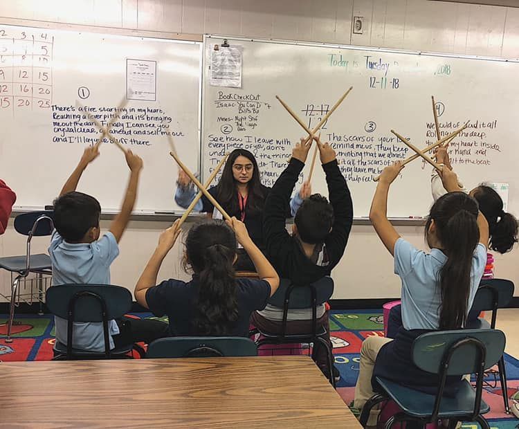 A teacher is teaching a group of children in a classroom