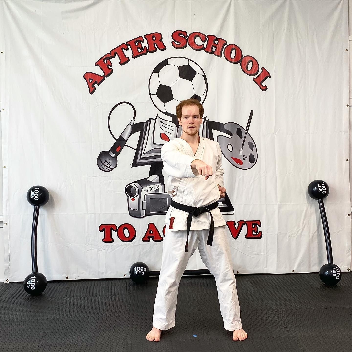 A man is standing in front of a banner that says after school