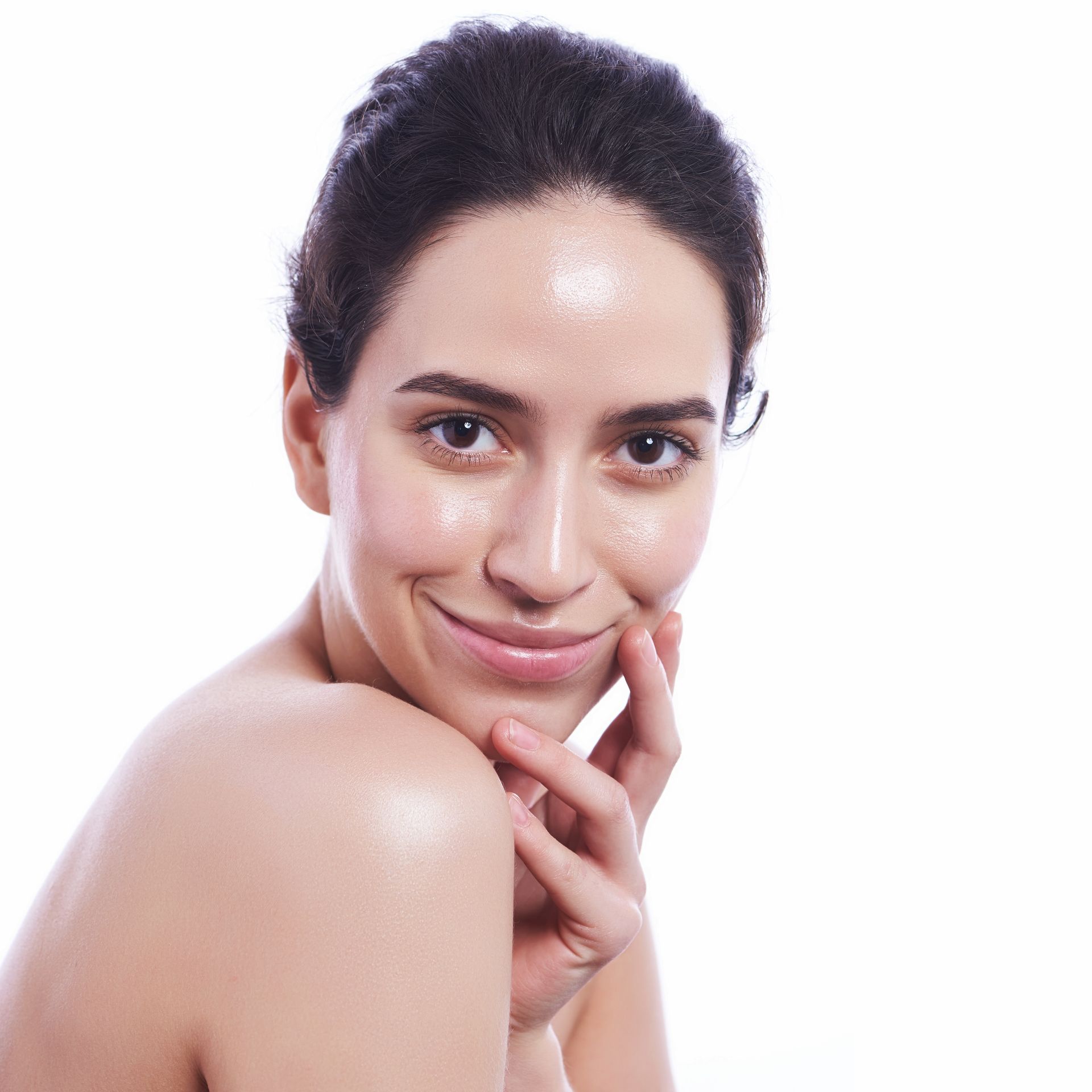 A woman is smiling and touching her face with her hand