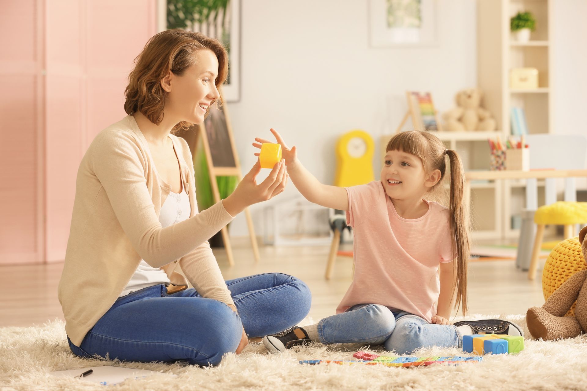 A Person Sits on a Rug With a Child — Moreton Bay Therapy in Rothwell, QLD