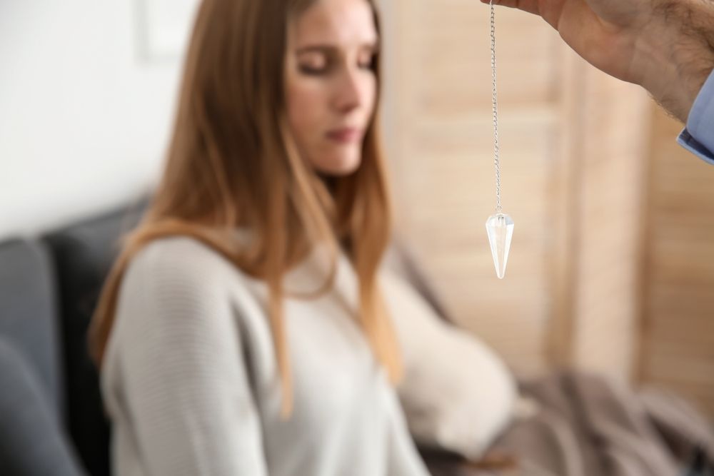 A Person Holds a Crystal Pendulum on a Chain — Moreton Bay Therapy in Clontarf, QLD