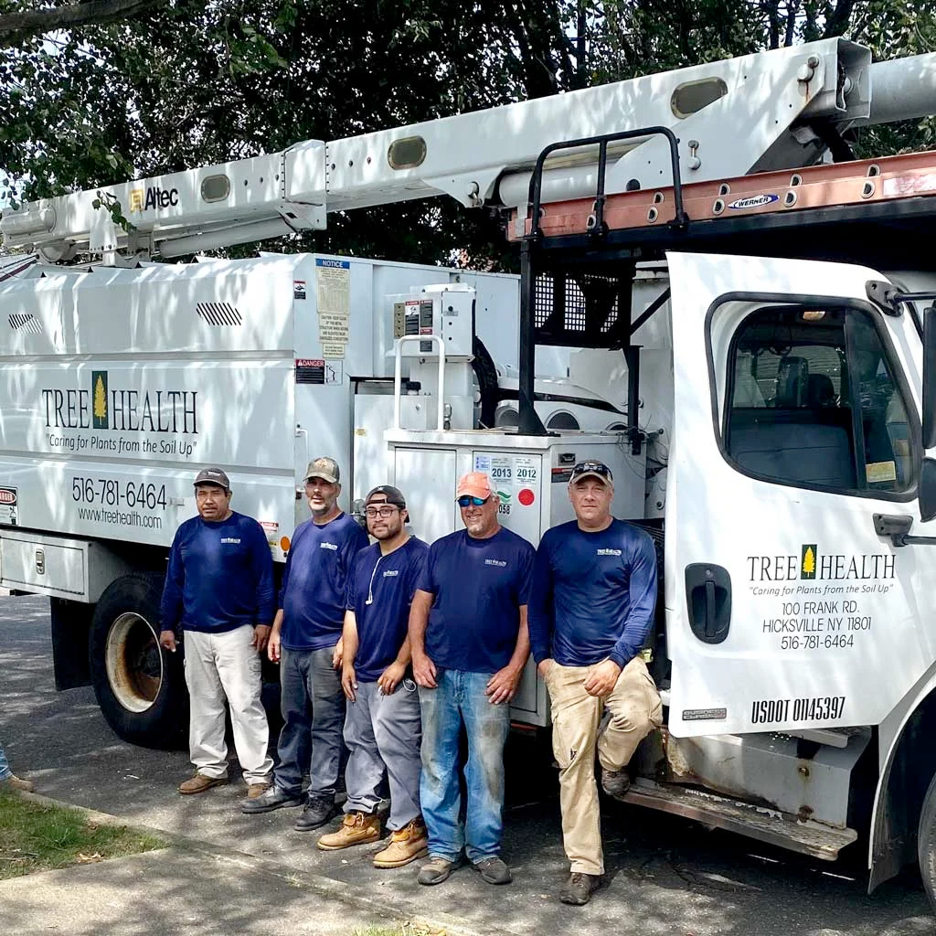 A group of men are posing for a picture in front of a truck.