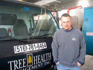 A man is standing in front of a tree health van.