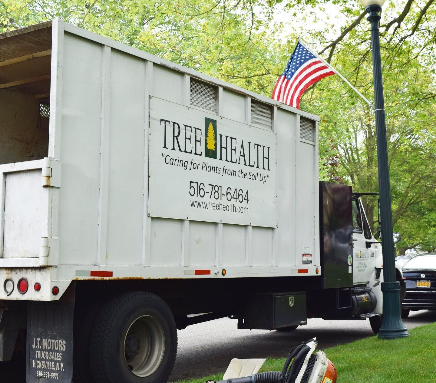 A tree health truck is parked on the side of the road
