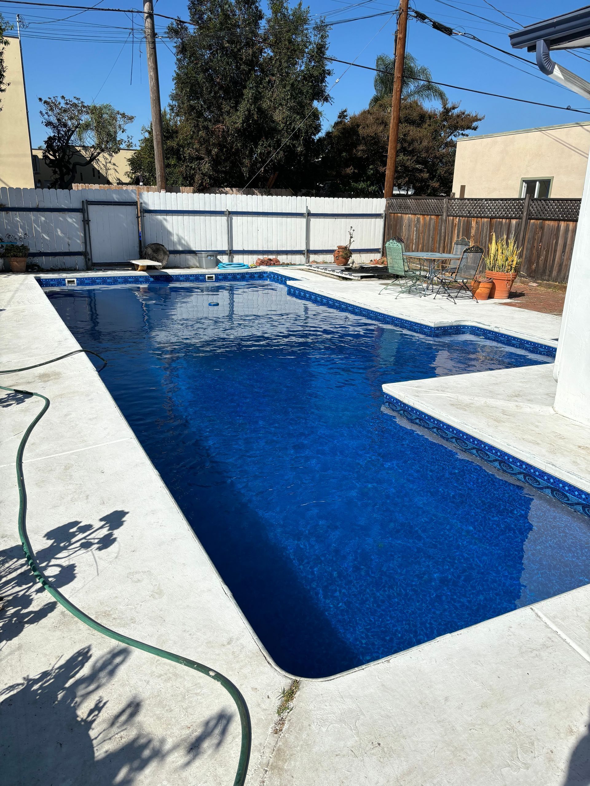 A large swimming pool with a hose attached to it