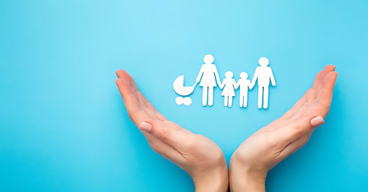 Hands surrounding figurines of a family (consisting of a mother, father, and three children).