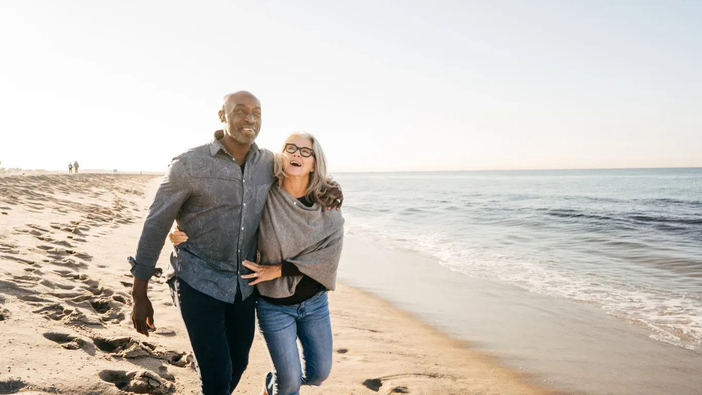 happy couple protected by life insurance enjoying life on the beach