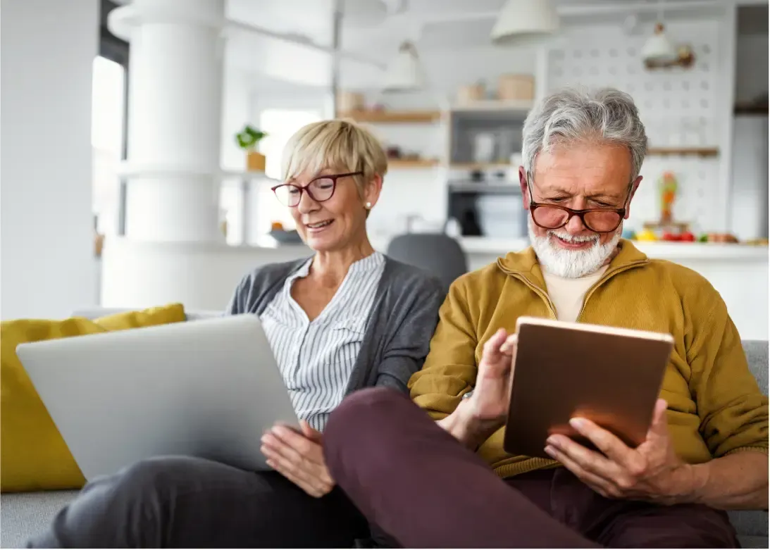 senior couple sitting on the couch learning about Medicare