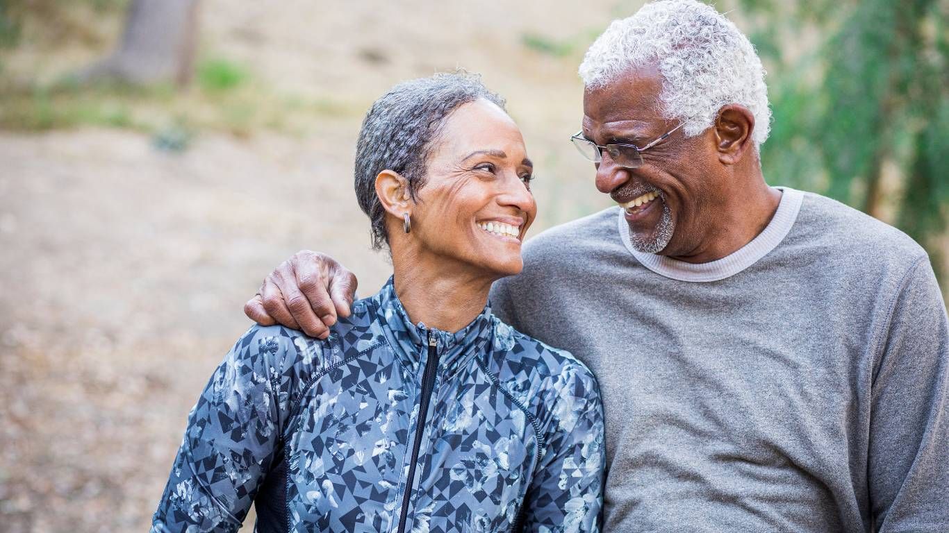 happy retired couple walking on a trail