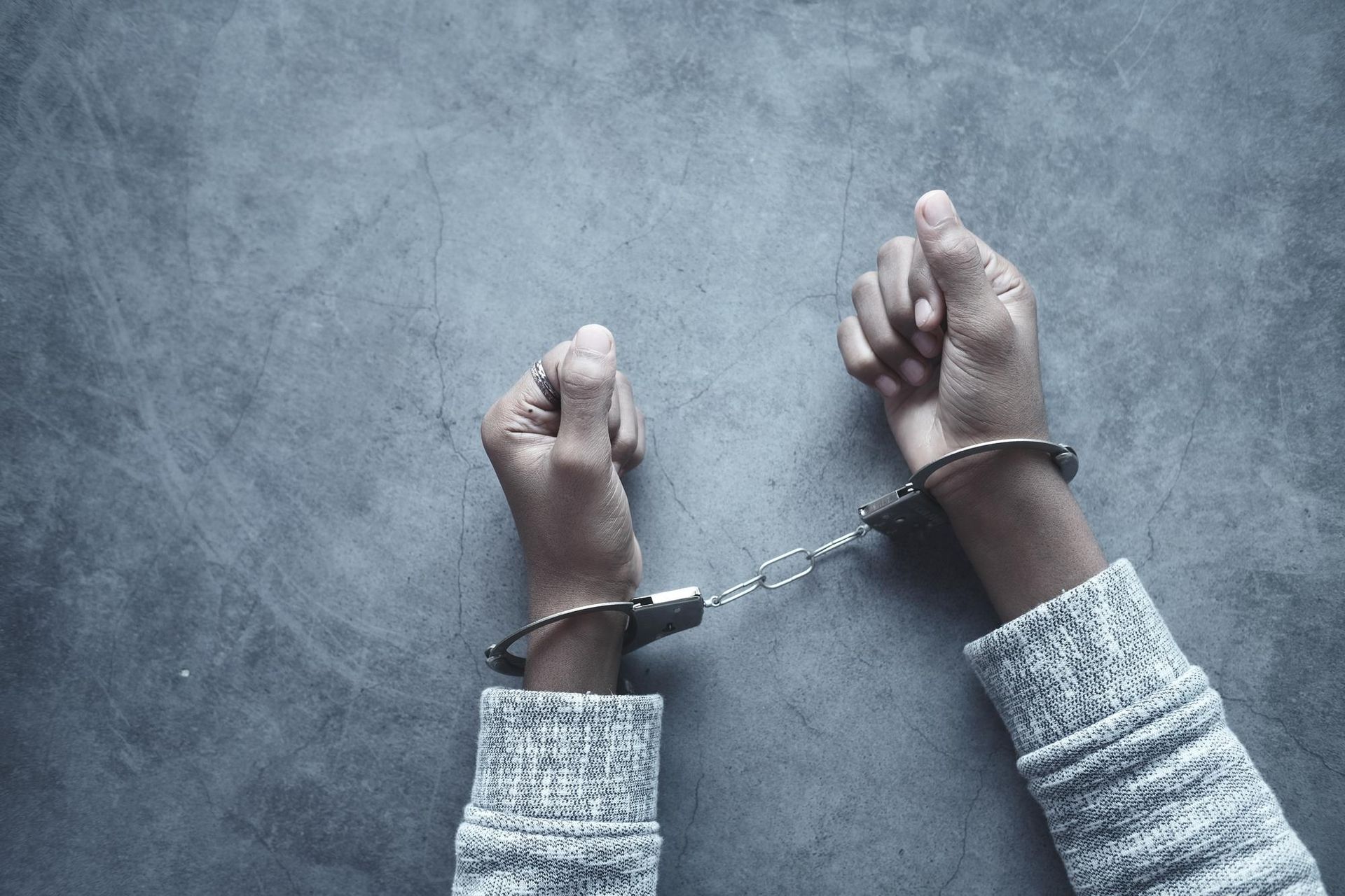 a person is wearing handcuffs on their hands .