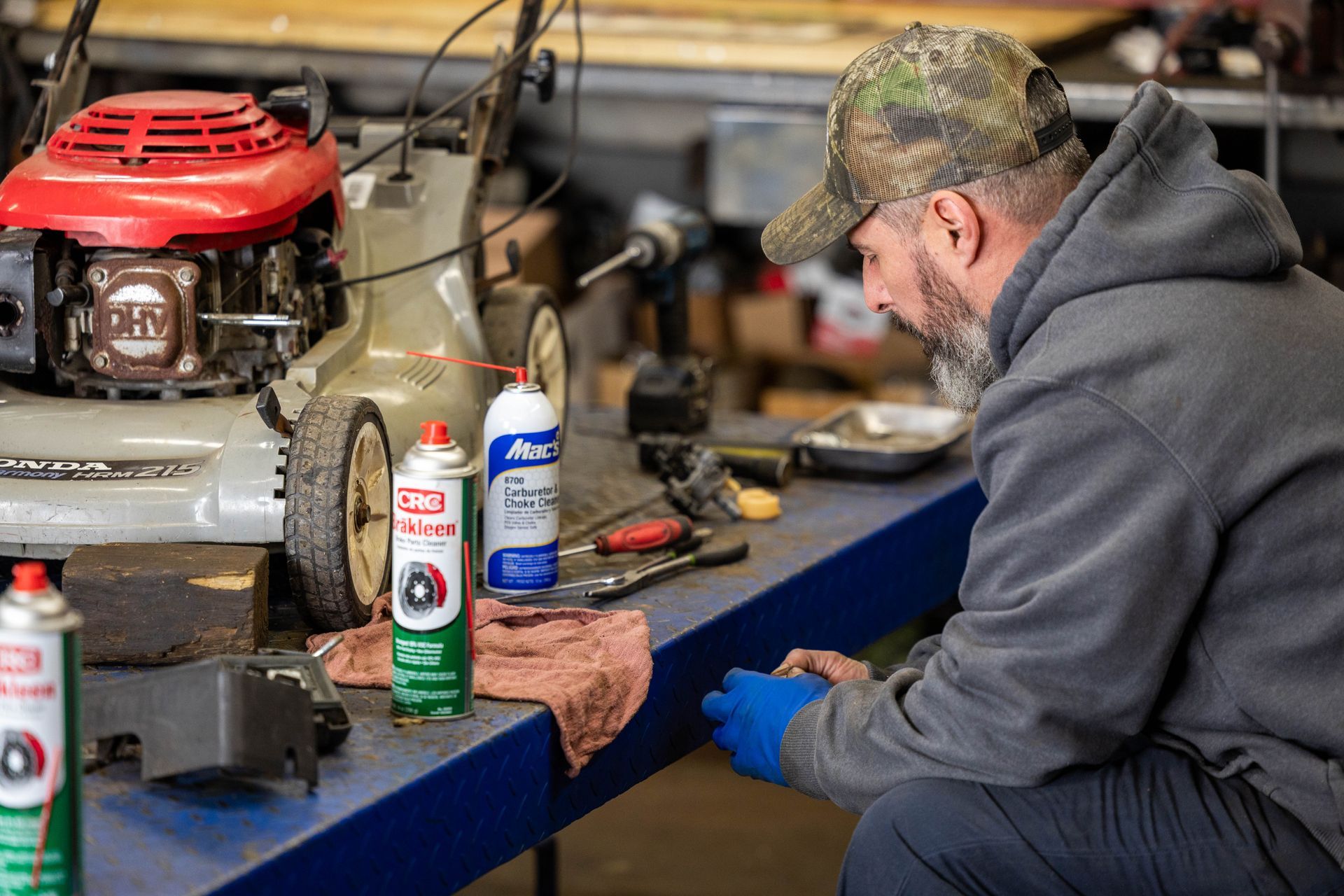A man is working on repairing a lawnmower