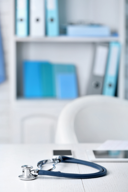 A pink hat is being embroidered on a sewing machine.
