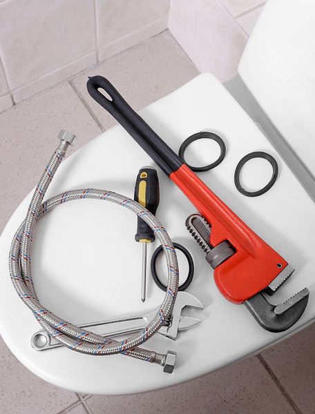 A Toilet With A Wrench Hose And Screwdriver On It