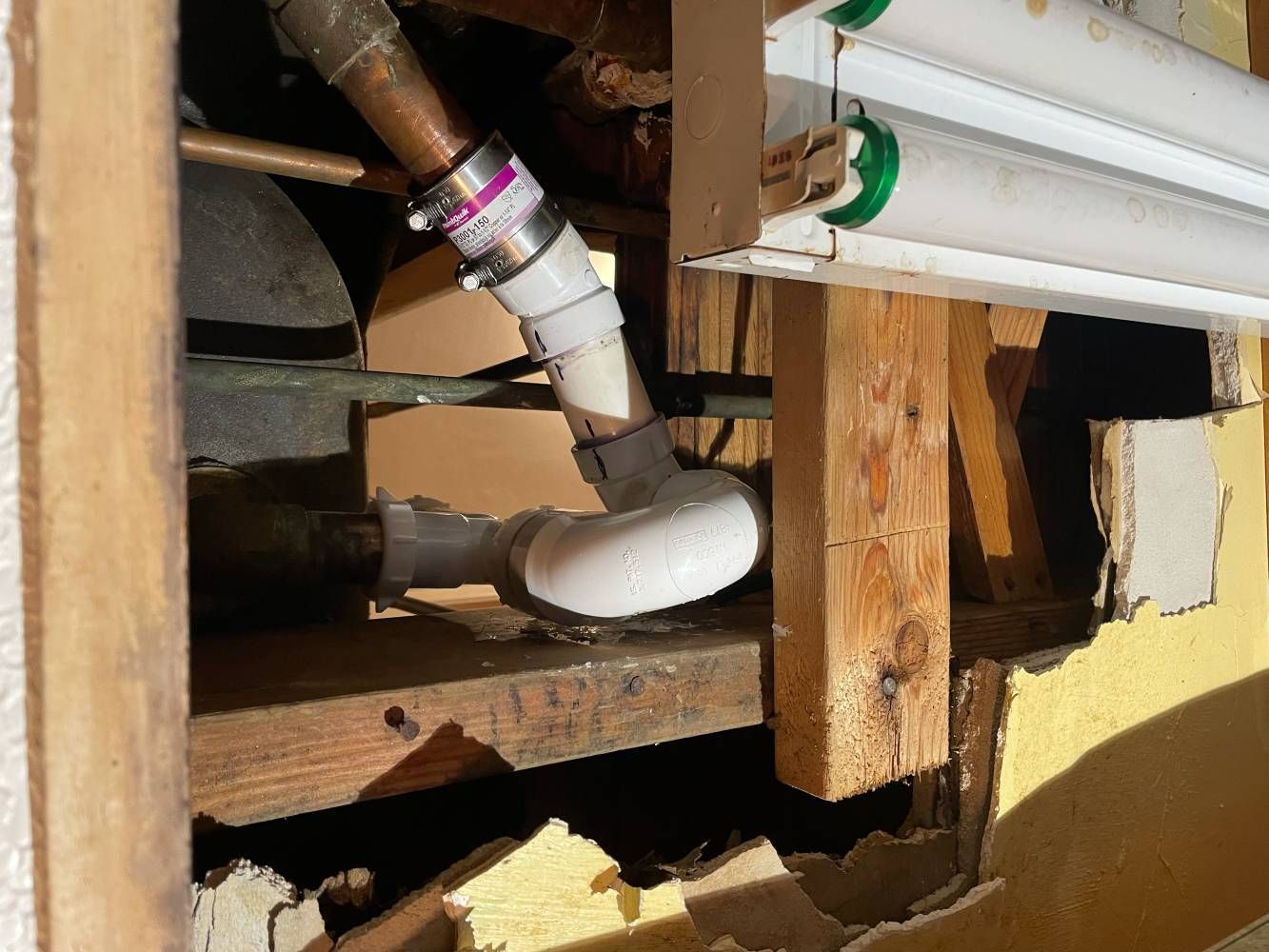 A pipe is coming out of a hole in a wall.