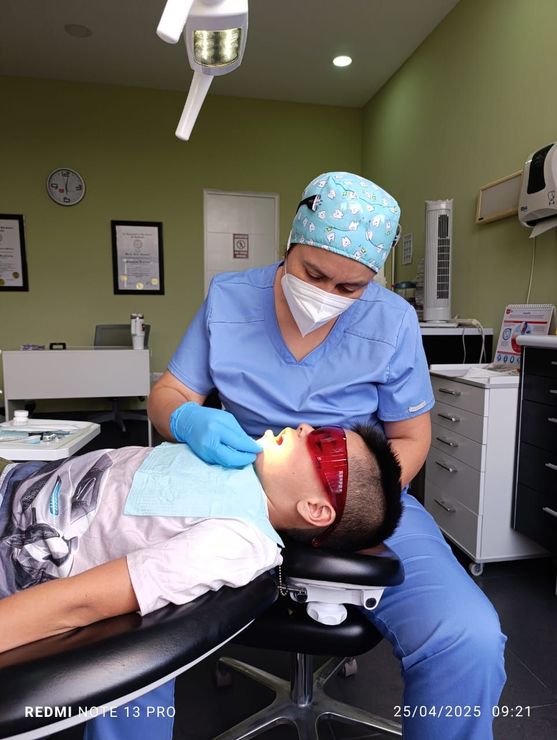 Una doctora en un consultorio dental atiende a un paciente niño.