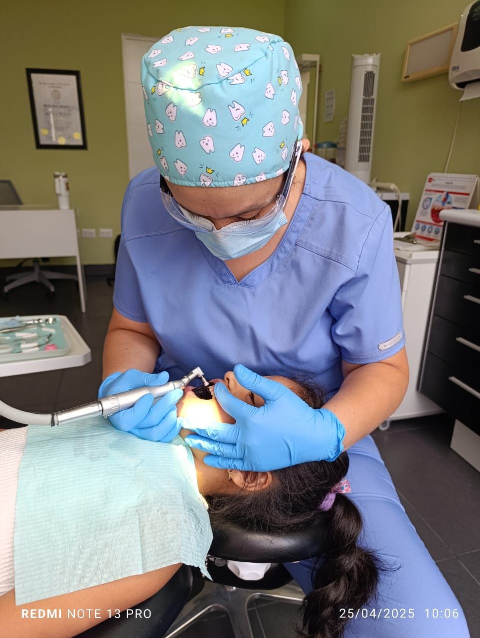 Una mujer está sentada en una silla dental mientras un dentista le examina los dientes.
