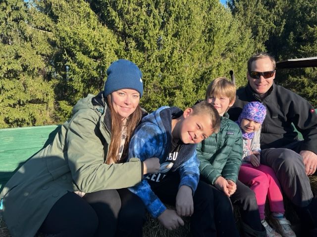 A family is sitting in the back of a truck.