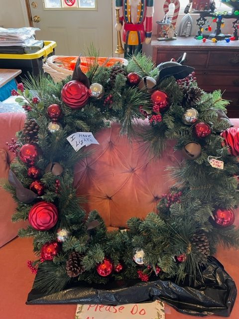 A christmas wreath with red and white decorations is sitting on a table.