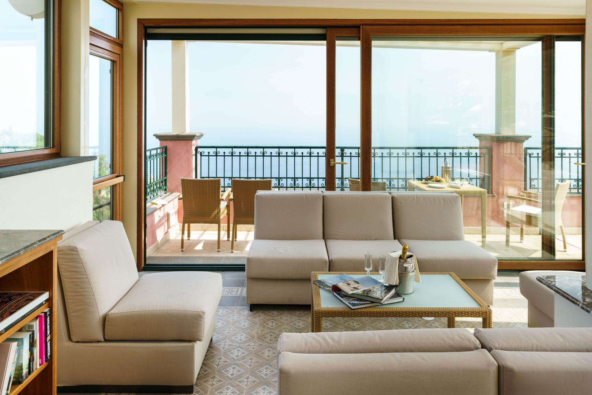Modern living room with beige sofas facing large windows and an ocean-view balcony