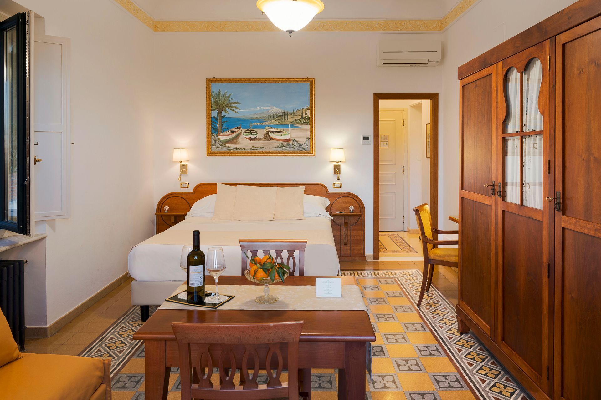 Cozy hotel room with twin beds, wooden cabinet, dining table, and tropical beach painting