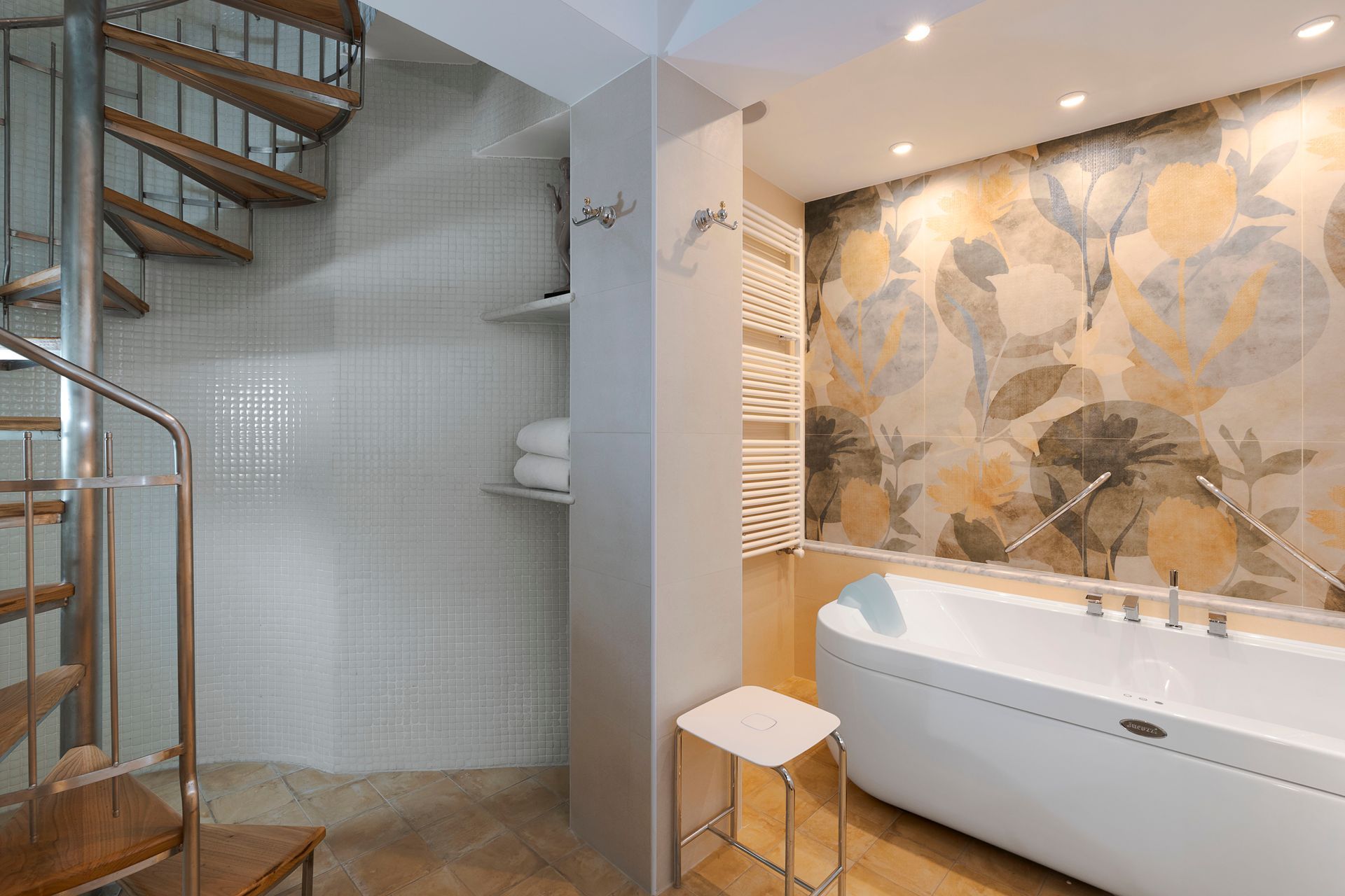 Bathroom with spiral staircase, tiled shower, and freestanding tub beside floral accent wall