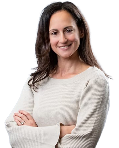 Woman with dark hair smiles, arms crossed, wearing a light-colored sweater.