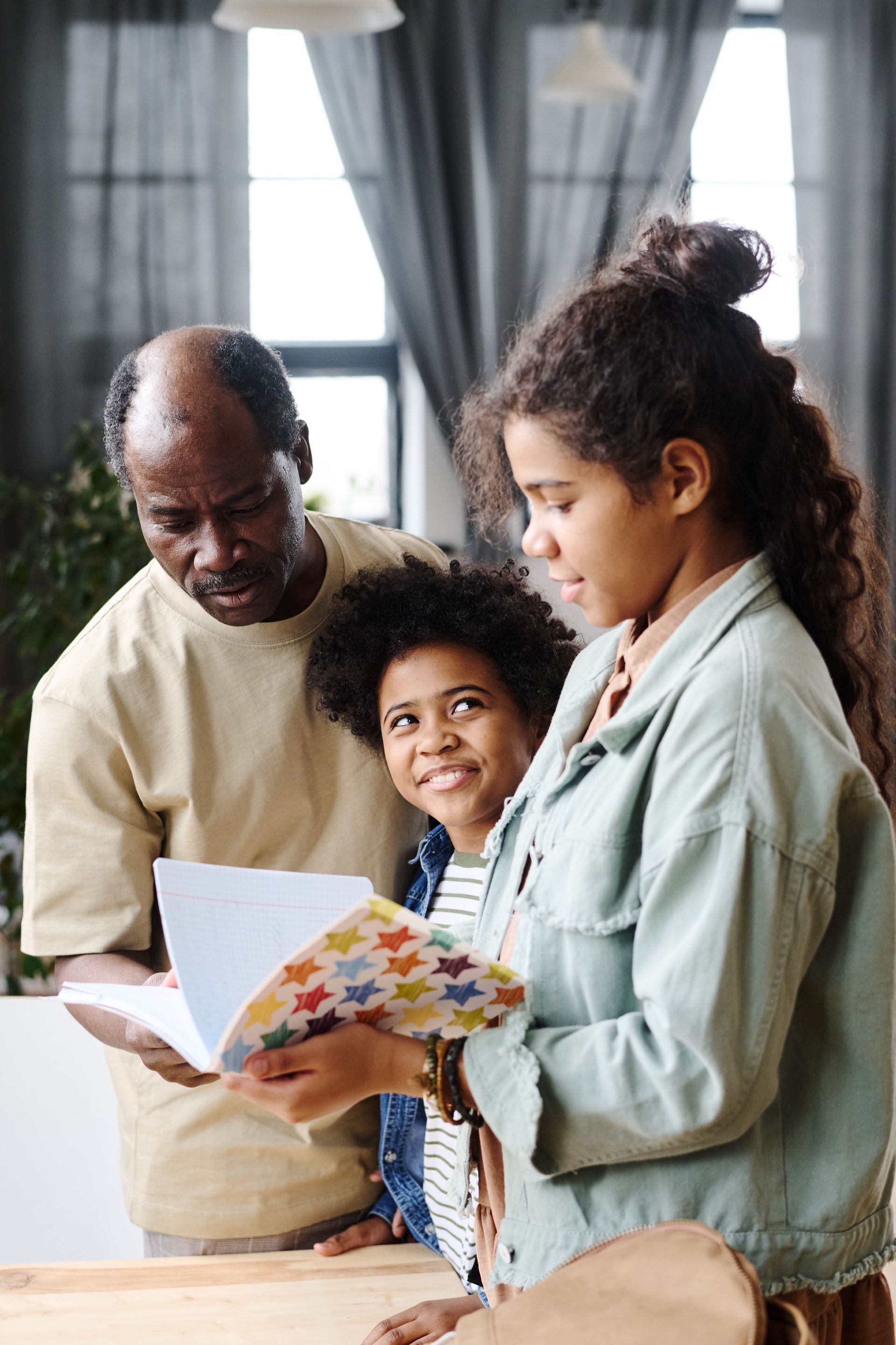 Man and two children looking at a colorful book.