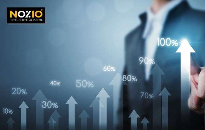 Uomo d'affari che indica una freccia rivolta verso l'alto con percentuali che indicano la crescita.