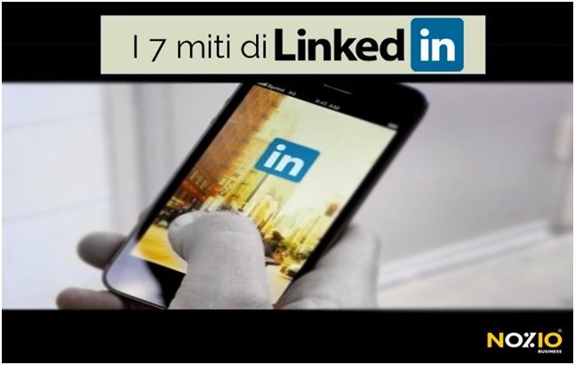 Mano che tiene uno smartphone con il logo di LinkedIn e la scritta 
