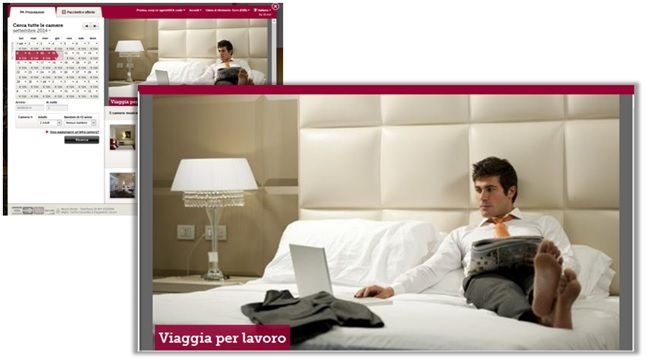 Un uomo è seduto sul letto di una stanza d'albergo e lavora al computer portatile