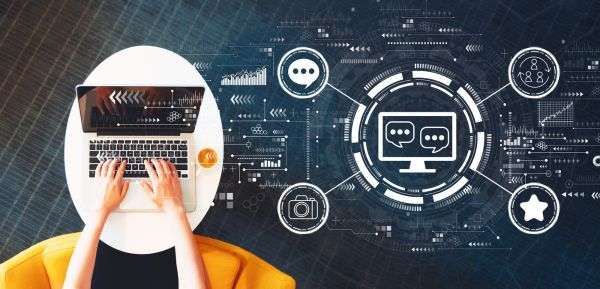 Persona che utilizza un computer portatile su un tavolo bianco, circondata da icone di interfaccia digitale.